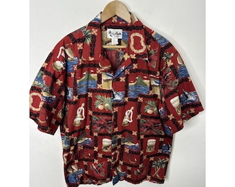 May include: Red short-sleeved button-down shirt with a tropical print featuring palm trees, flowers, and fish. The shirt has a collar and a button-up front. The label on the shirt reads "Kailua"
