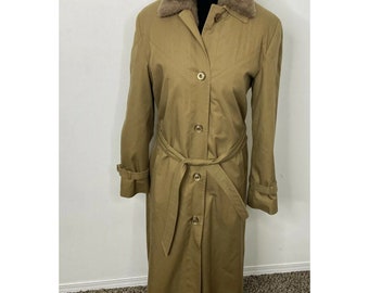 Peut inclure: Un long manteau beige en trench avec un col en fausse fourrure et une ceinture. Le manteau a une fermeture à boutons et des manches longues.