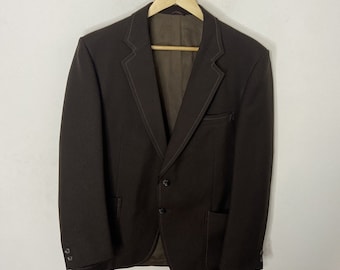 Peut inclure: Un blazer marron avec une fermeture à trois boutons et une poche unique sur le côté gauche. Le blazer a une doublure marron et des détails de couture marron.
