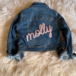 Personalized jean jacket with hand embroidery. 
Molly with special request all lower case lettering. Baby pink felt with baby pink thread.