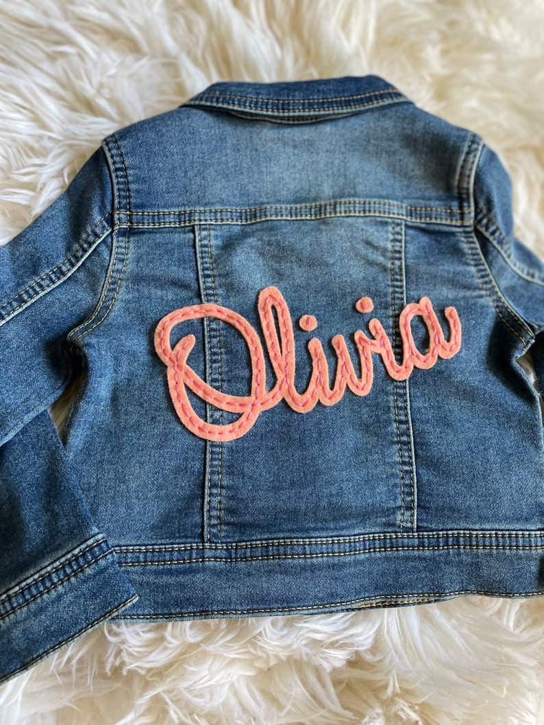 Personalized jean jacket with hand embroidery.
Olivia with coral felt and coral thread.