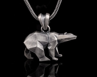 Op de afbeelding: Een zilveren ketting met een geometrische berenhanger. De beer is gemaakt van zilver en heeft een getextureerd oppervlak.