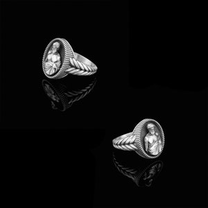 Puede incluir: Un anillo de plata con un dise&ntilde;o detallado de la cabeza de un hombre en un marco ovalado. La banda del anillo est&aacute; trenzada.