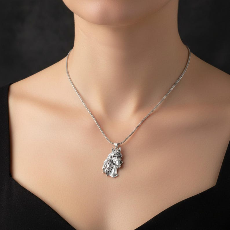 Puede incluir: Un collar con colgante plateado con un dise&ntilde;o detallado de cabeza de caballo. El colgante de caballo tiene una melena fluida y rasgos realistas. La cadena del collar es una fina cadena de plata. Un elegante accesorio de tem&aacute;tica ecuestre. La cadena mide unos 45 cm.