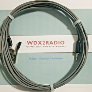 May include: A grey coiled antenna cable with a black connector on one end and a black alligator clip on the other end. The cable is labelled "WDX2RADIO Portable Shortwave Radio Antenna" and "Indoor / Outdoor / Anywhere".