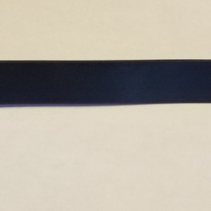 May include: A black electrical bus bar with copper terminals and blue insulated connectors. The bus bar is rectangular and has a bolt on each end. The terminals are secured with silver bolts.