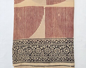 May include: Folded beige fabric with a maroon striped pattern and a black floral border. The fabric has a geometric design with vertical stripes and a decorative edge.