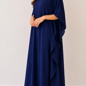May include: A floor-length, solid navy blue kaftan dress featuring a V-neckline and wide, flowing cape-style sleeves. The garment is crafted from a lightweight, draped fabric that falls loosely to the floor, creating a relaxed and elegant silhouette.