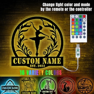 May include: A black metal silhouette of a ballerina with floral accents, illuminated with a warm glow. The sign reads "CUSTOM NAME EST. 2023" and features 16 color options. The image also shows a remote control and a USB cable.