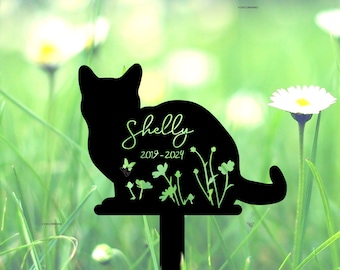 May include: Black silhouette of a cat with the name "Shelly" and the dates "2019-2024" inscribed on it. The silhouette is surrounded by small green flowers and butterflies. The silhouette is on a black metal stake.