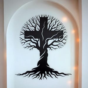 Puede incluir: Un diseño de cruz en forma de árbol negro sobre un fondo blanco. La cruz está formada por las ramas y el tronco de un árbol, con raíces en la base. El diseño está situado dentro de una alcoba arqueada, creando un efecto visual llamativo.