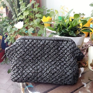 Cartera de mano hecha a mano de color verde oscuro con apariencia de cuero