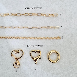 May include: Three gold-toned metal chains labeled 1, 2, and 3 under the text CHAIN STYLE, and three gold-toned metal clasps labeled 1, 2, and 3 under the text LOCK STYLE. The clasps include a heart-shaped swivel, a heart-shaped lobster, and a ring.