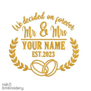 May include: Gold embroidery design featuring a wreath of leaves, two intertwined rings, and the text "We decided on forever Mr & Mrs YOUR NAME EST. 2023".