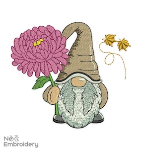 Puede incluir: Diseño bordado de un gnomo sosteniendo una flor rosa con un sombrero marrón y una barba blanca. Dos hojas doradas se encuentran en la esquina superior derecha del diseño.