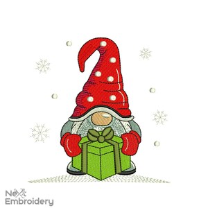 Può includere: Un gnomo rosso e bianco con un cappello lungo e appuntito tiene una scatola regalo verde con un fiocco verde. Il gnomo è in piedi su uno sfondo bianco con fiocchi di neve.