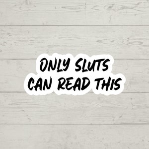Pode incluir: Etiqueta branca com texto preto que diz "ONLY SLUTS CAN READ THIS" em um fundo de madeira.