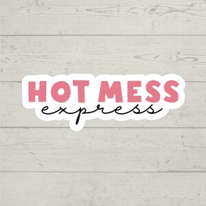 以下が含まれることがあります： ピンクと白のステッカーに、黒い文字で「HOT MESS express」と書かれています。