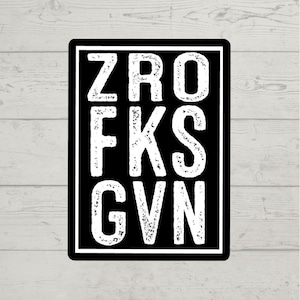 Puede incluir: Adhesivo rectangular negro con el texto blanco "ZRO FKS GVN" en una fuente audaz y desgastada. La pegatina tiene un borde blanco y está sobre un fondo de vetas de madera clara.