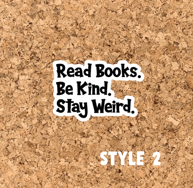 May include: A corkboard with a black and white sticker that reads "Read Books. Be Kind. Stay Weird." The sticker is on a corkboard background. The text "STYLE 2" is printed in white below the sticker.