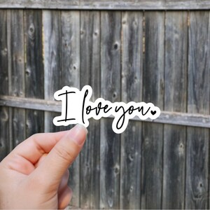 May include: White sticker with the text "I love you" written in black cursive with a small heart symbol at the end.