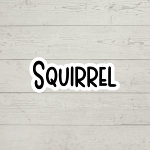 May include: A black and white sticker with the word "SQUIRREL" written in a playful, rounded font.