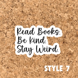 May include: White sticker with black text on a cork background. The text reads "Read Books. Be Kind. Stay Weird."  The text "STYLE 7" is printed in white below the sticker.