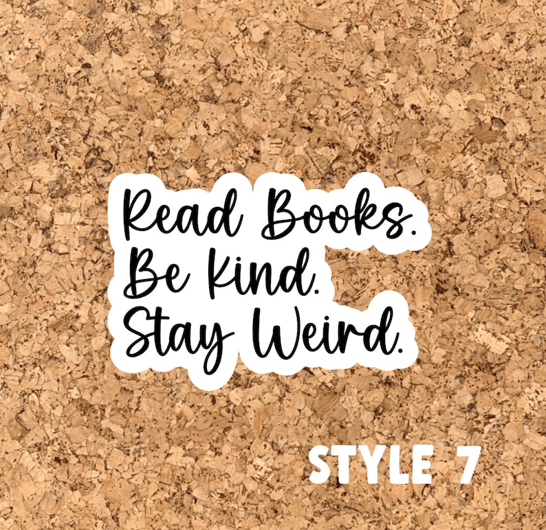 May include: White sticker with black text on a cork background. The text reads "Read Books. Be Kind. Stay Weird."  The text "STYLE 7" is printed in white below the sticker.