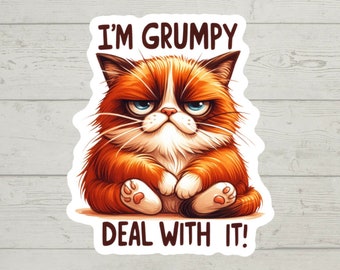 May include: A grumpy-looking orange tabby cat with blue eyes sits with its paws crossed and a frown on its face. The text "I'm Grumpy Deal With It!" is written above and below the cat.