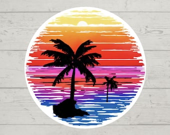 Könnte beinhalten: Ein runder Aufkleber mit einem Sonnenuntergang über dem Meer und zwei Palmen. Der Sonnenuntergang ist ein Farbverlauf von Orange, Rot, Rosa und Lila. Das Meer ist blau mit weißen Wellen. Die Palmen sind schwarze Silhouetten.