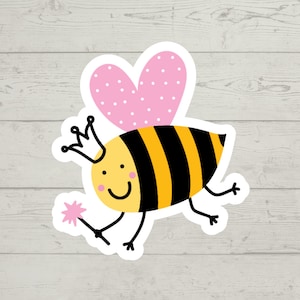 May include: A cartoon bee with a pink heart-shaped wing, a yellow and black striped body, a crown, and a wand. The bee is smiling and has a happy expression.