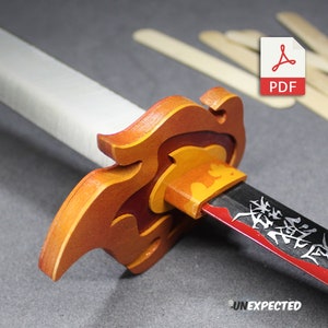 May include: A wooden sword with a red and orange flame design on the hilt. The blade is black with red accents and has Japanese characters on it. The sword is on a gray surface with wooden craft sticks in the background.