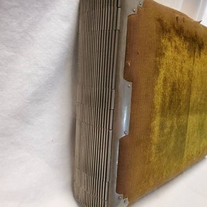 May include: A vintage photo album with a green velvet cover and a silver metal hinge. The album is closed and the hinge is visible.