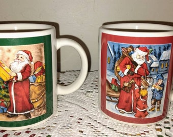 May include: Two white ceramic mugs with Christmas-themed designs. One mug features a green background with Santa Claus holding a gift in front of a Christmas tree. The other mug has a red background with Santa Claus delivering gifts to two children.