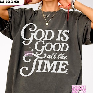 Puede incluir: Una camiseta gris oscura con un gráfico blanco desgastado que dice "God is Good all the Time".