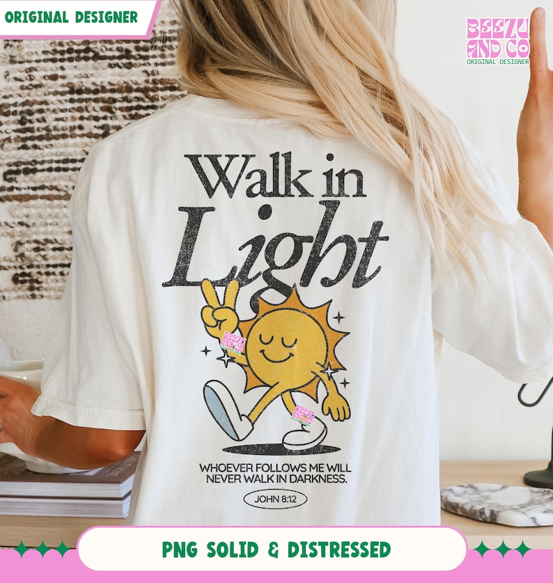 May include: Cream-colored t-shirt with a graphic of a smiling sun giving a peace sign, with the words "Walk in Light" above it. The text "WHOEVER FOLLOWS ME WILL NEVER WALK IN DARKNESS. JOHN 8:12" is printed below the sun. The shirt also has the text "PNG SOLID & DISTRESSED".
