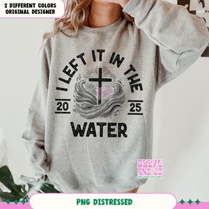 May include: A gray sweatshirt with a distressed black graphic design that reads "I Left It In The Water" with a cross and waves. The graphic also includes the numbers 20 and 25.