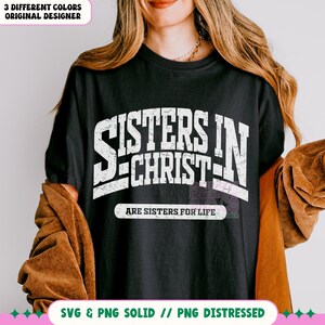 May include: A black t-shirt with white text that reads "Sisters in Christ are sisters for life".