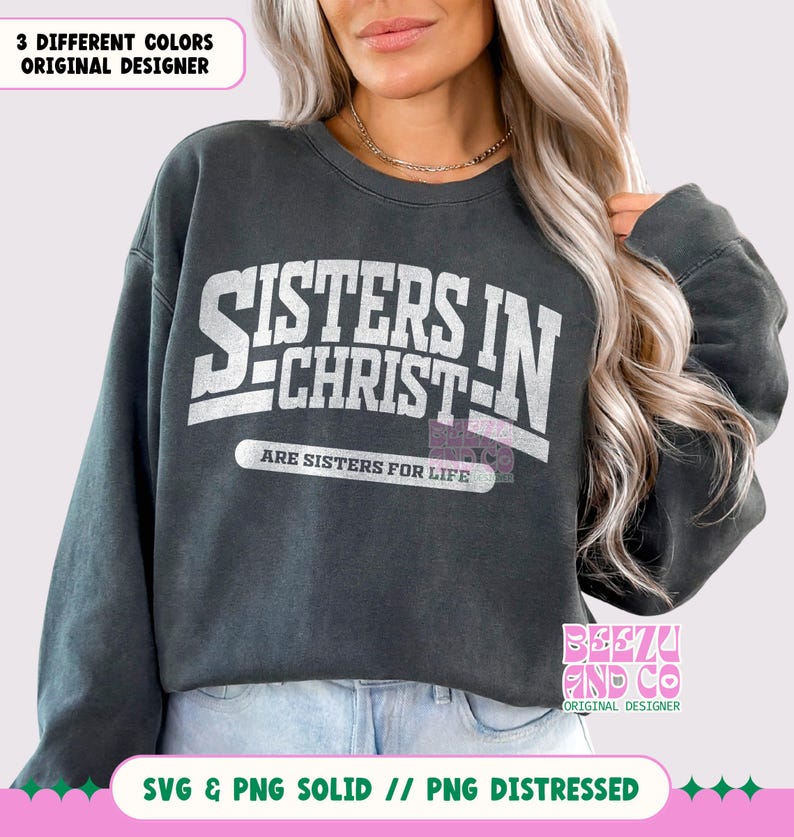 May include: A dark gray sweatshirt with the text "Sisters in Christ" in white lettering. The text is in a vintage style font and is surrounded by a white border. The text "Are Sisters for Life" is printed below the main text in a smaller font.