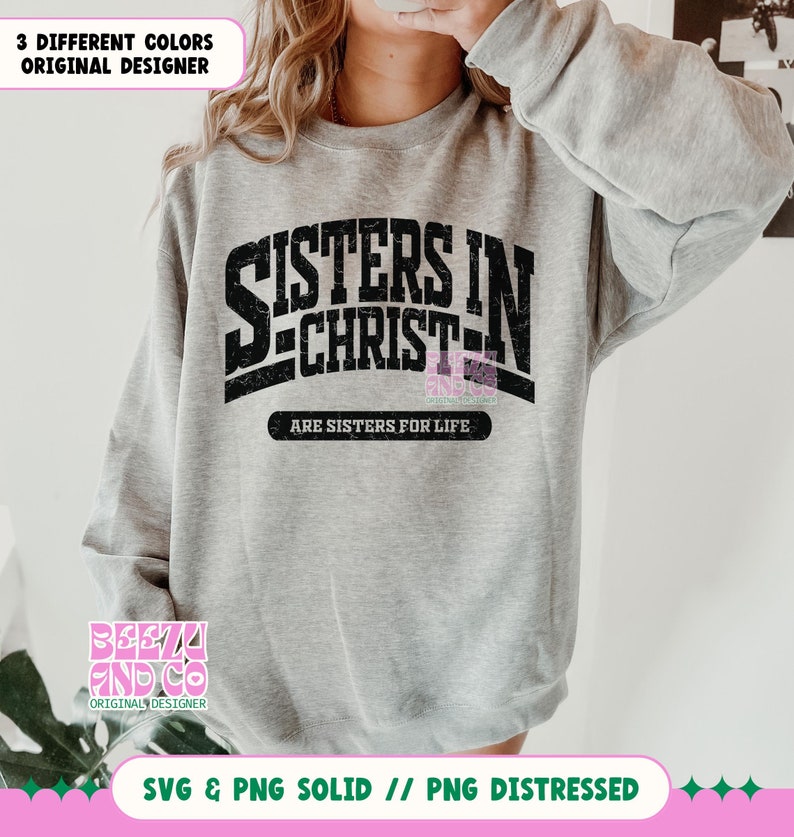 May include: A gray sweatshirt with the text "Sisters in Christ" in black with a distressed look. The text "Are Sisters for Life" is below in smaller black text.