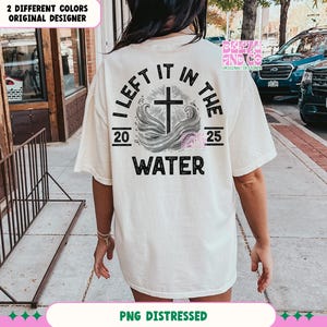 May include: A white t-shirt with a distressed black graphic that says "I left it in the water" with a cross and waves. The numbers 20 and 25 are on either side of the graphic.