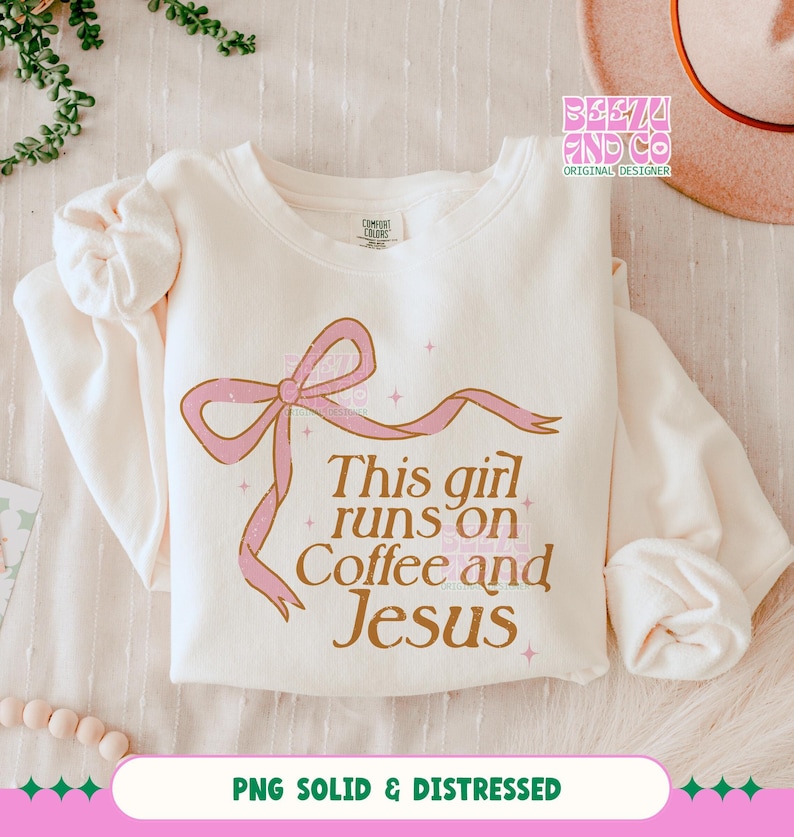 May include: A white sweatshirt with a pink bow and the text "This girl runs on Coffee and Jesus" in brown lettering. The text has a distressed look.