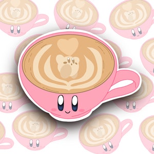 May include: A pink coffee cup with a cartoon face and a heart-shaped latte art design. The latte art is a brown bear with a pink nose and eyes.