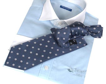 May include: A light blue dress shirt with a white collar and a navy blue tie with white polka dots. The shirt has a logo that says "Seven New".