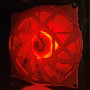 Könnte beinhalten: Ein roter Computerlüfter mit einem schwarzen und weißen Symbol in der Mitte. Der Lüfter ist mit rotem Licht beleuchtet.