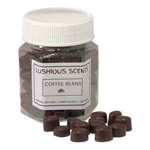 May include: A glass jar filled with brown wax melts shaped like coffee beans. The jar has a white lid and a label that reads "LUSHIOUS SCENTS COFFEE BEANS NATURAL SOY WAX | HAND POURED | 100 GR", with a small image of a coffee bean.