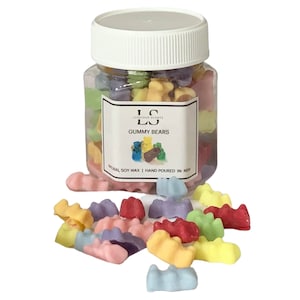 May include: A glass jar filled with colourful gummy bear shaped soy wax melts. The jar has a white lid and a label that says "Luxurious Scents" and "Gummy Bears". The label also says "Natural Soy Wax | Hand Poured in India".