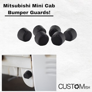 Może przedstawiać: Zestaw sześciu czarnych gumowych osłon zderzaka do Mitsubishi Mini Cab. Osłony zostały zaprojektowane w celu ochrony zderzaków pojazdu przed zarysowaniami i wgnieceniami. Obraz pokazuje również zbliżenie jednej z osłon zamontowanych na białym pojeździe.
