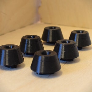 Könnte beinhalten: Sechs schwarze, konische Möbelfüße aus Kunststoff.