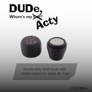 Puede incluir: Pomo de cambio negro con un patrón de cambio rojo "135 H 24R". El pomo tiene un compartimento oculto para un Apple AirTag. El texto "DUDE, Where's my? Acty" está en el fondo.